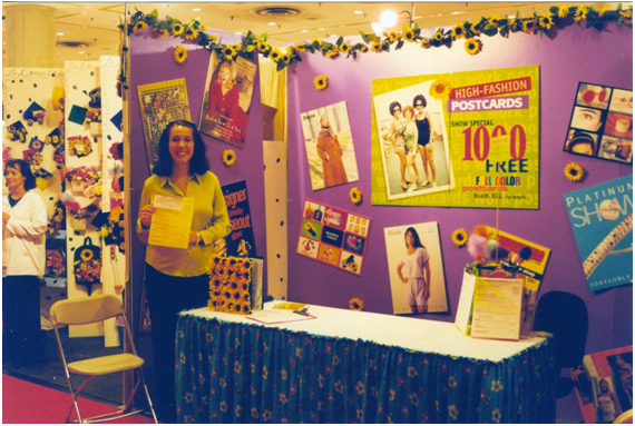 Joy standing in front of PostcardMania booth