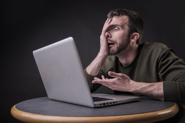 frustrated man looking at laptop screen