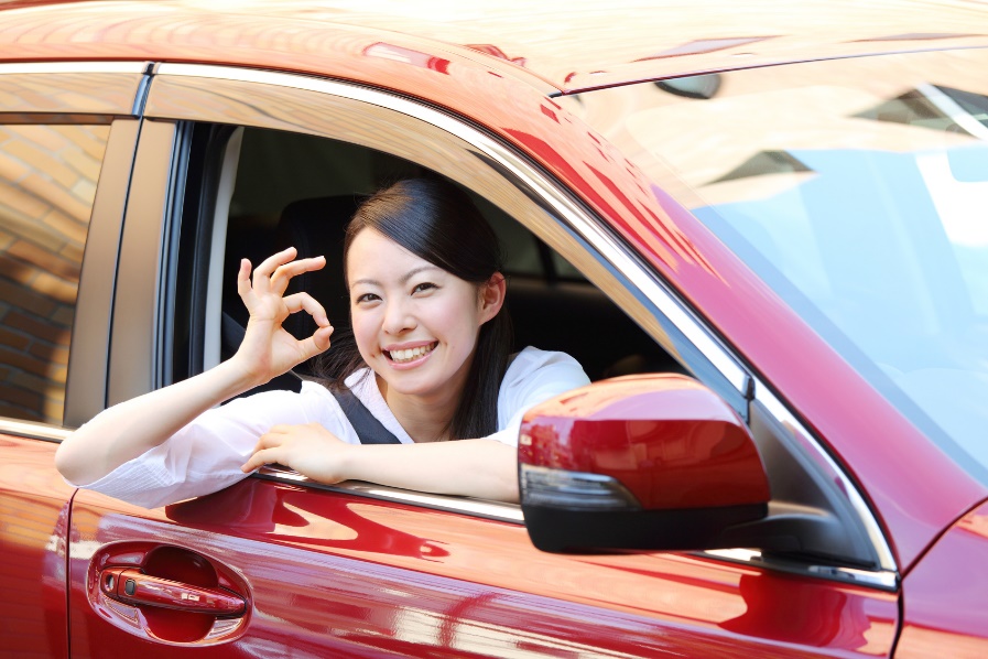 woman in car giving ok sign
