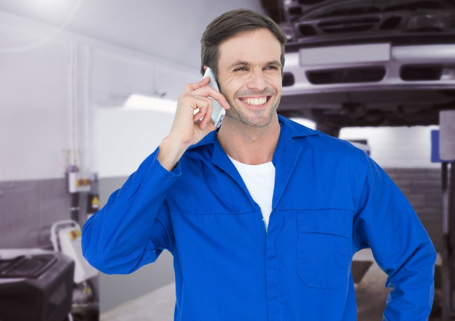 auto repair worker smiling on phone