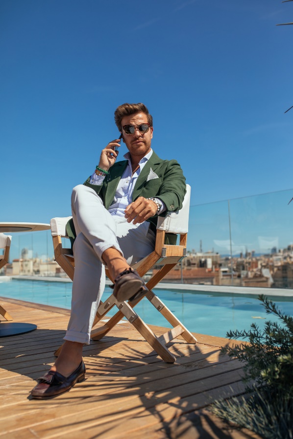 man in business suit sitting by a pool