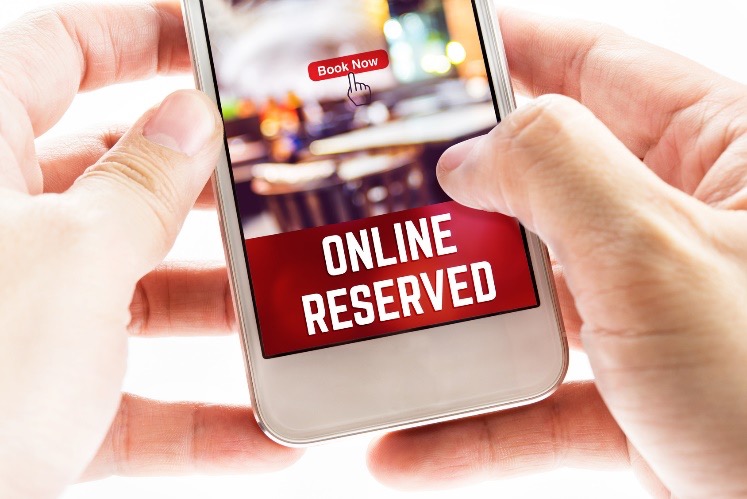 person making restaurant reservation on smartphone