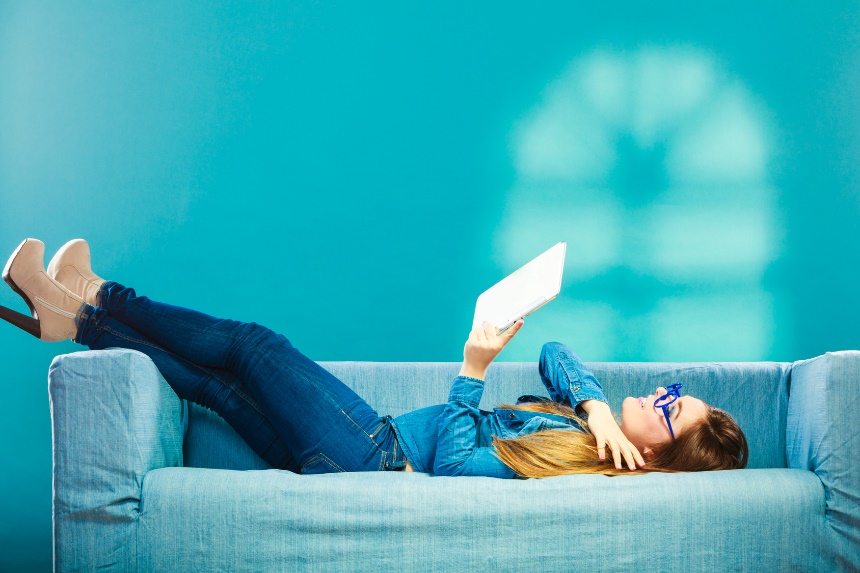 woman lounging and looking at her tablet