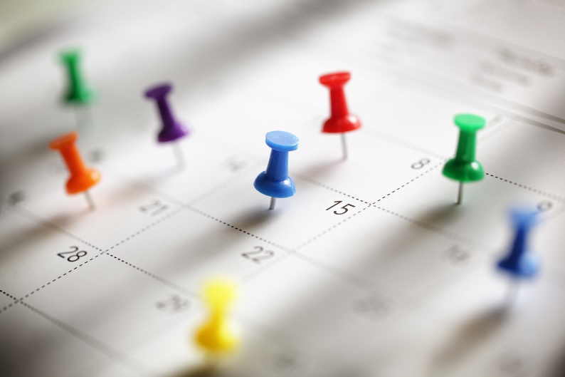 thumbtacks marking days on a calendar